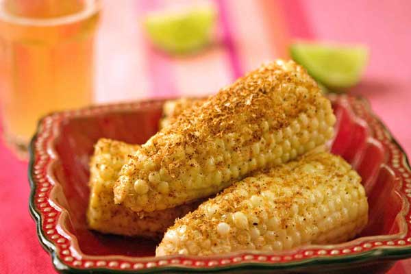 Elotes are coated in a creamy chili sauce.